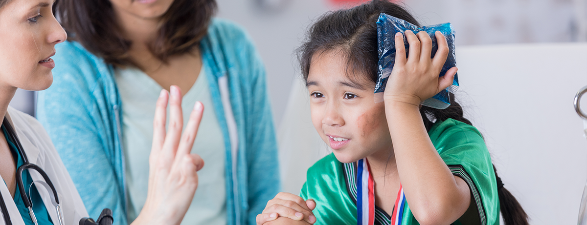 injured child holding ice pack to head