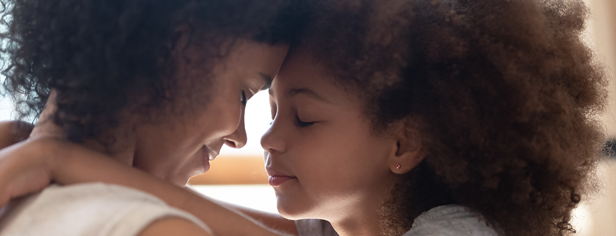 mother and daughter pressing foreheads together with eyes closed