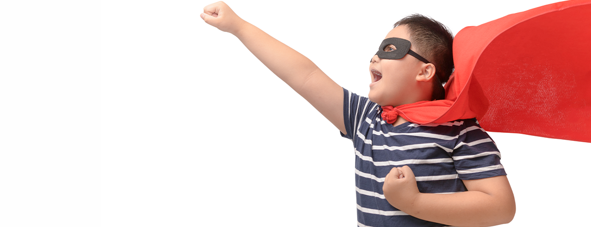 young asian boy in super hero cape and mask