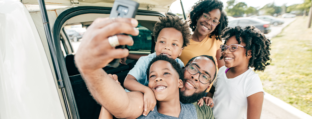 black family taking selfie in back of car
