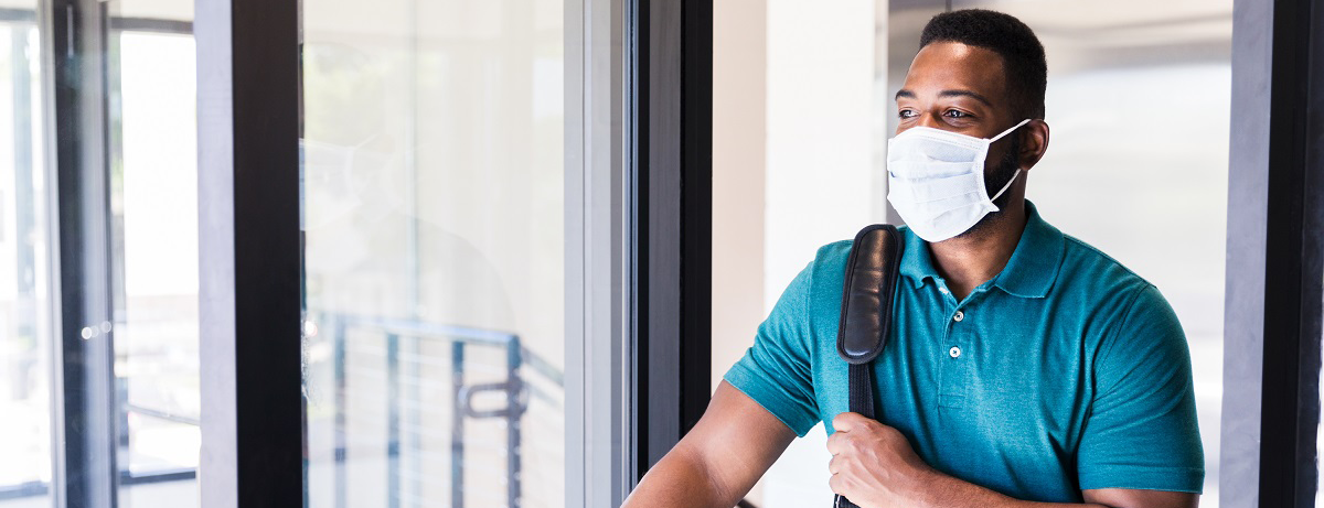 masked black man walking into a building