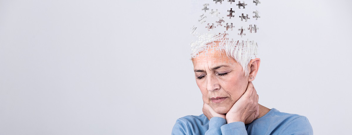 woman with eyes closed grasping neck and head turning into puzzle pieces