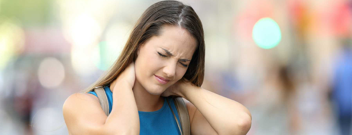 young woman grasping neck in pain