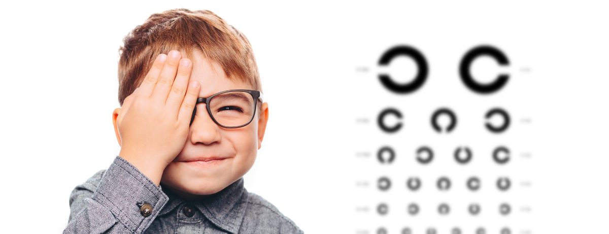 young boy squinting at eyechart