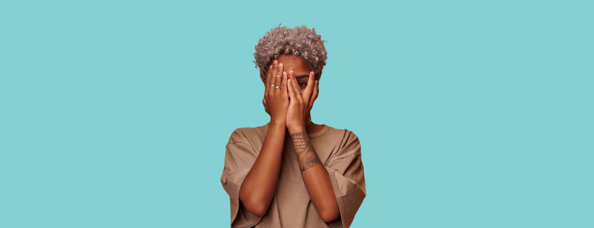 black woman covering face with hands