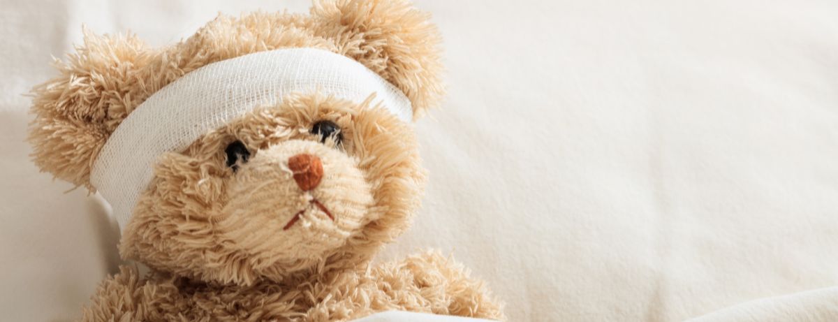 Sad teddy bear with head bandage